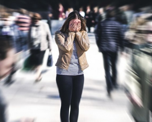 young-woman-in-crowd-covering-face-768