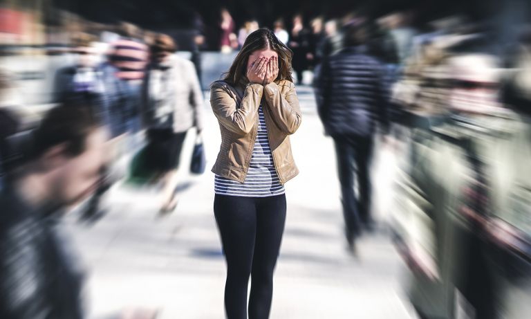 young-woman-in-crowd-covering-face-768