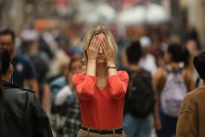 donna tra la folla con le mani sugli occhi